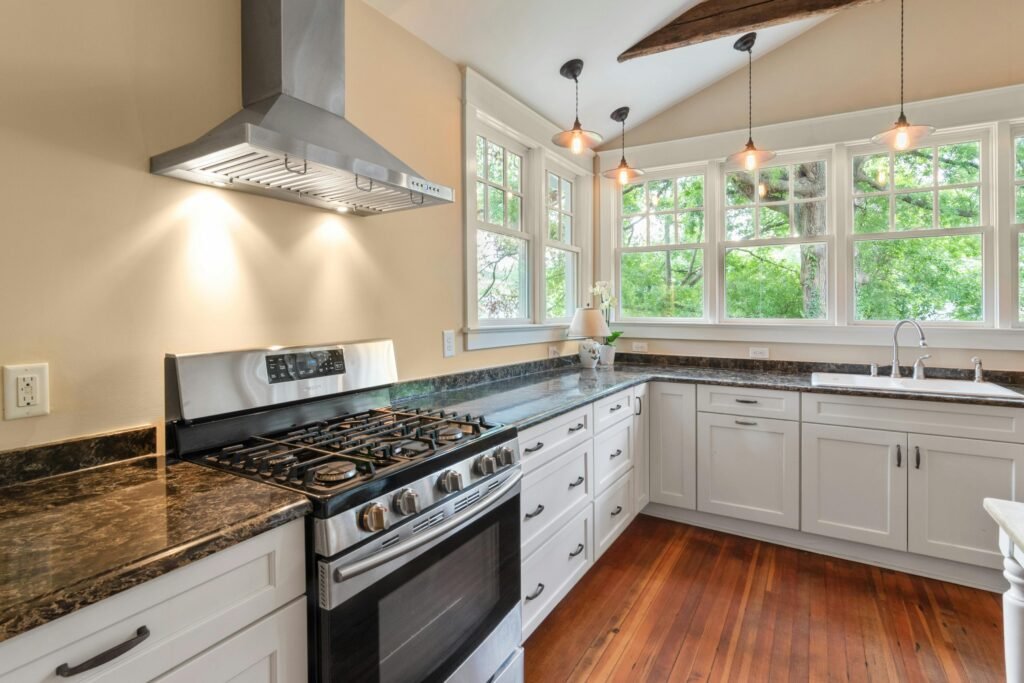 Bright modern kitchen with gas range, white cabinets, and natural light.
